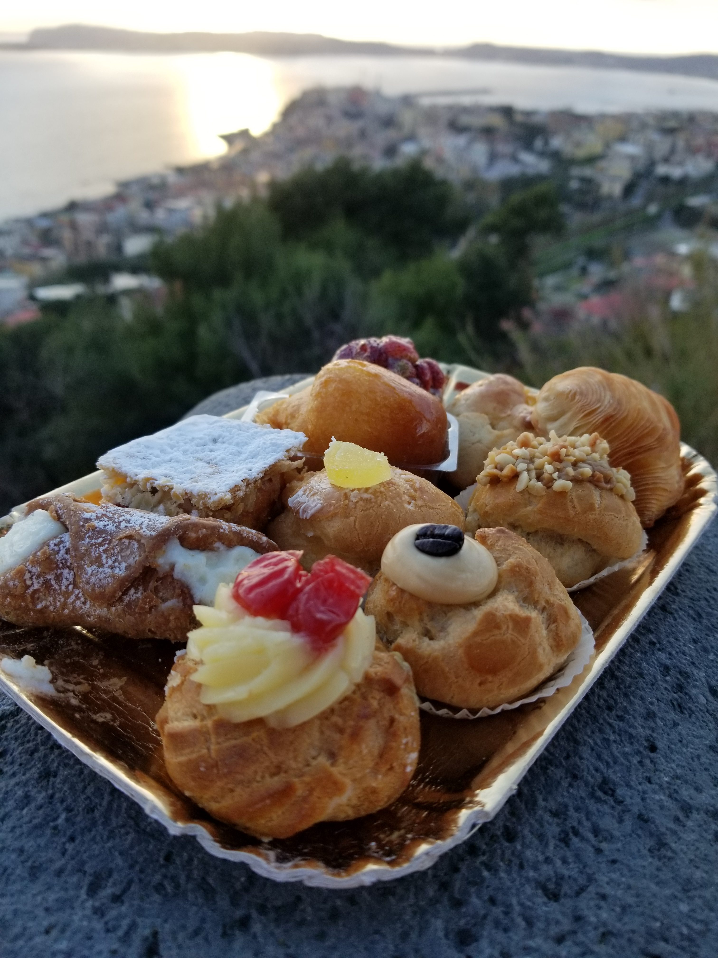 Tray of pastries with sea and city background italy